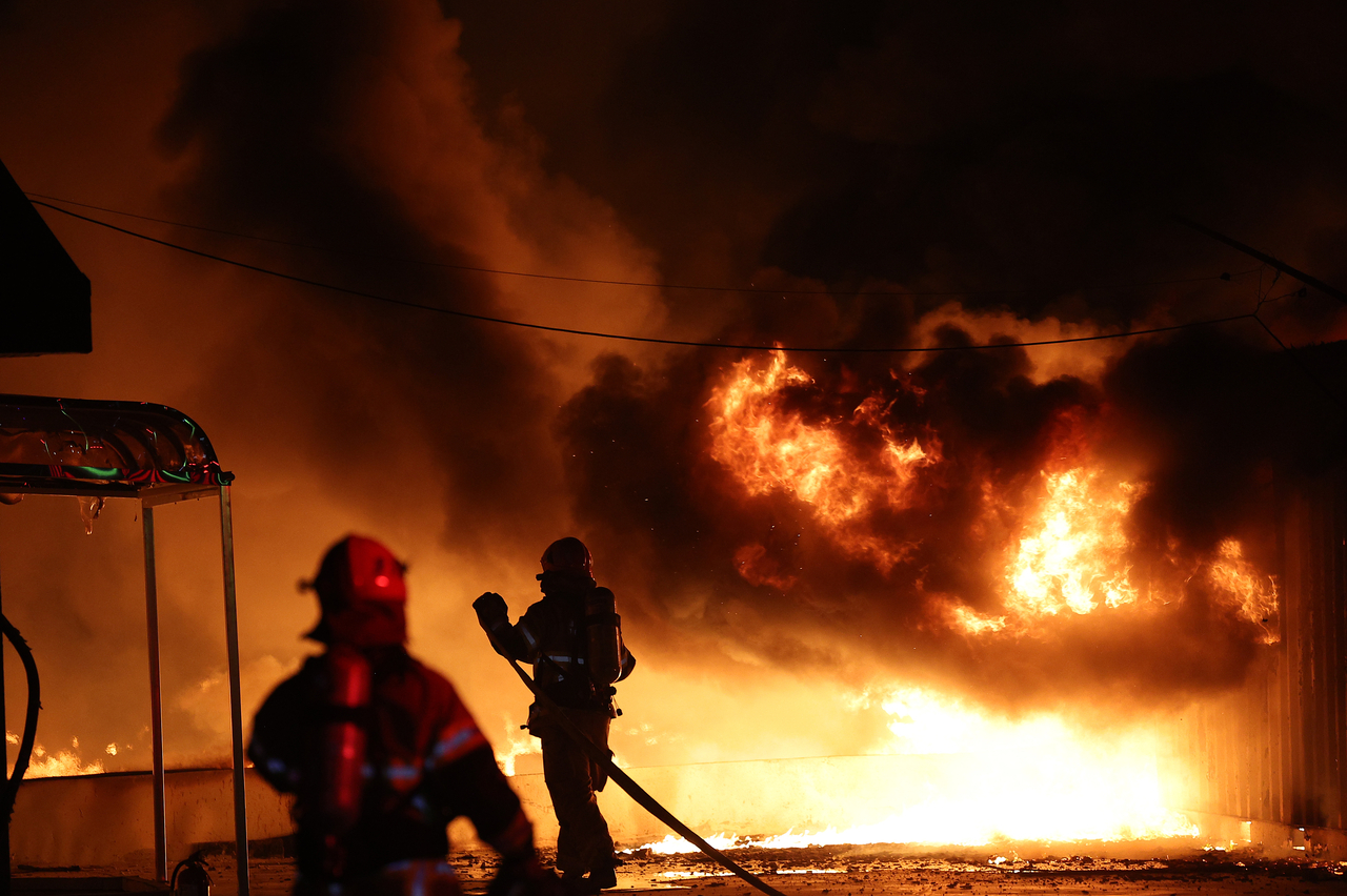 Firefighters extinguish a fire at a factory building that has been engulfed in a wildfire in Uiseong County, North Gyeongsang Province, Saturday. (Yonhap)