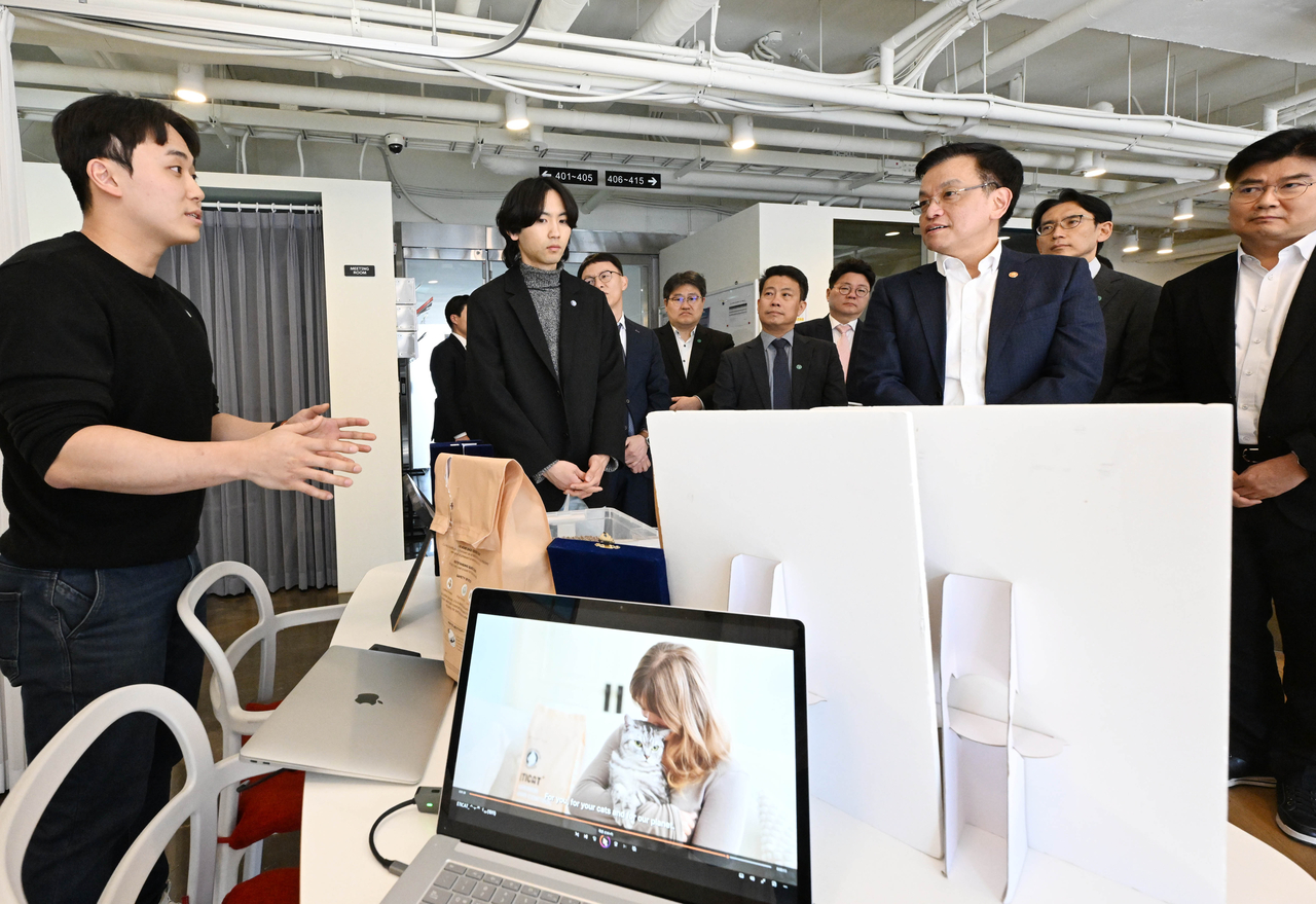 Finance Minister Choi Sang-mok, who was also serving as acting president and prime minister at the time, listens to Alfred Pets CEO Kwon Soon-woo explain eco-friendly innovations, including upcycled cat litter, during a visit to the Yeoksam Youth Startup Hub in Seoul on March 17. (Newsis)
