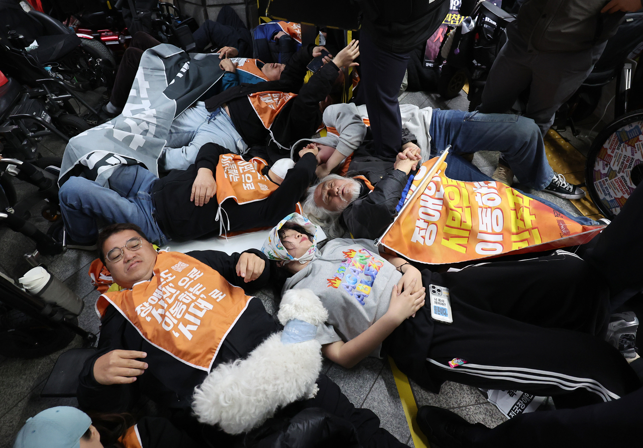 Activists and members of disabled rights group stage a "die-in," calling for mobility rights of the physically challenged at the platform of Gyeongbokgung Station in Jongno-gu, Seoul, Thursday. (Yonhap)