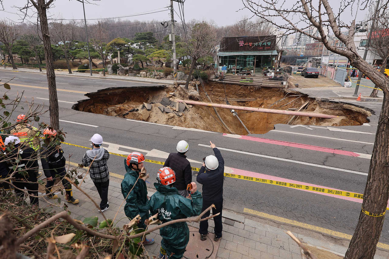 The 20-meter-wide and 18-meter-deep sinkhole that formed at an intersection in Gangdong-gu, eastern Seoul, Monday evening is seen in this photo on Tuesday. (Yonhap)