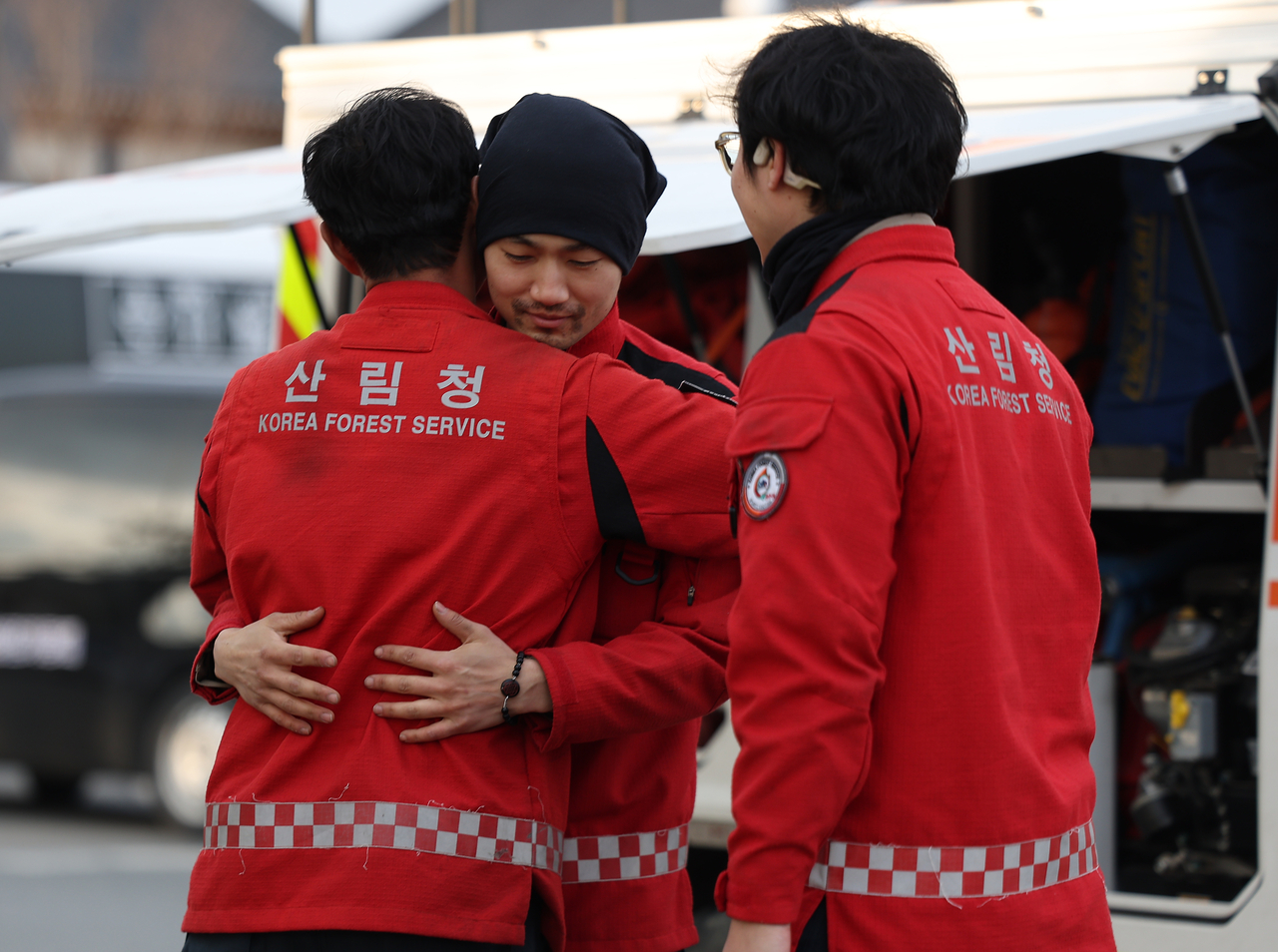 Firefighters encourage each other after extinguishing wildfires on Friday. (Yonhap)