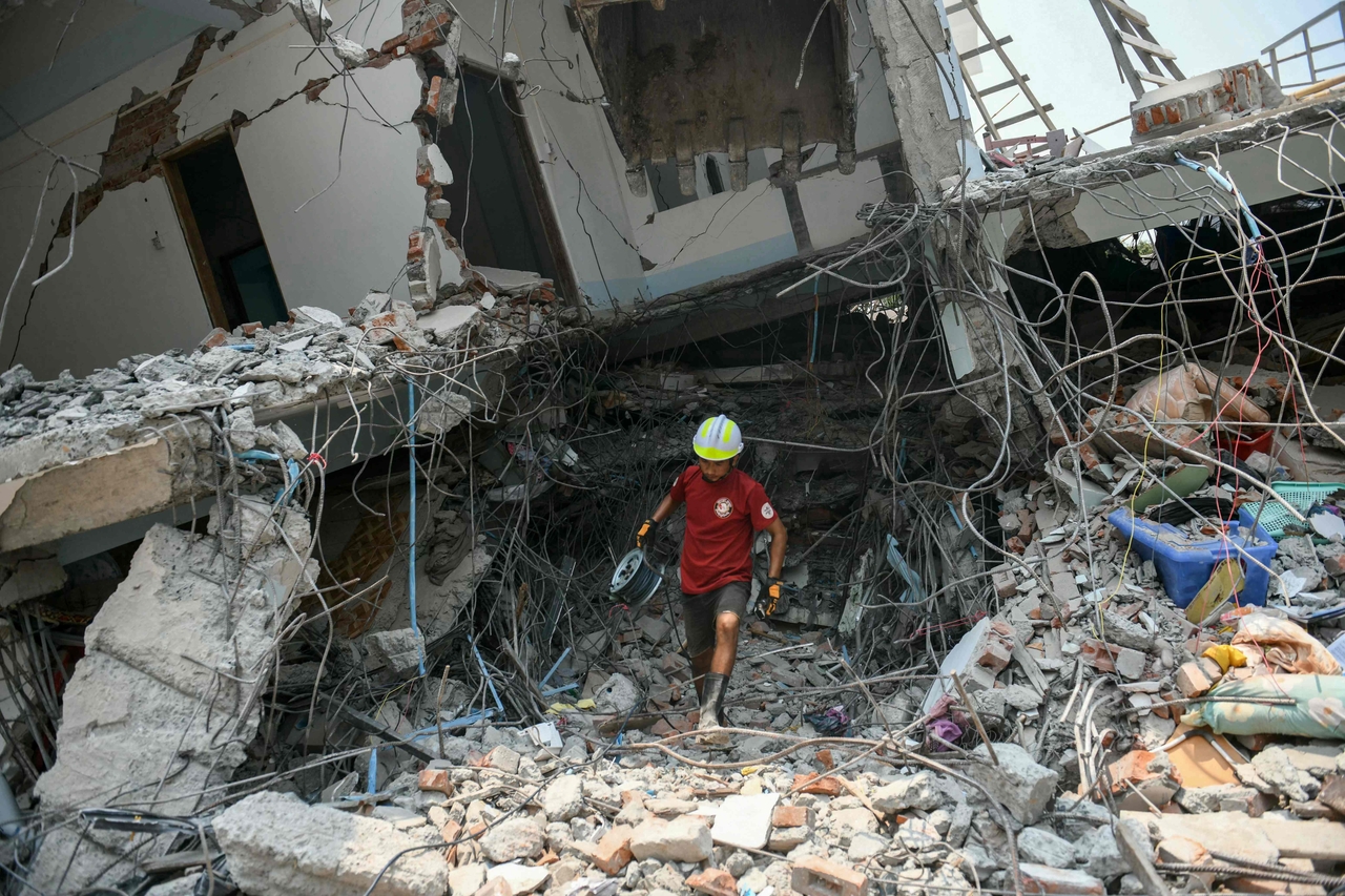 A rescuer carries equipment as a team searches through the rubble of a destroyed building looking for survivors in Mandalay on Saturday, a day after an earthquake struck central Myanmar. (AFP-Yonhap)