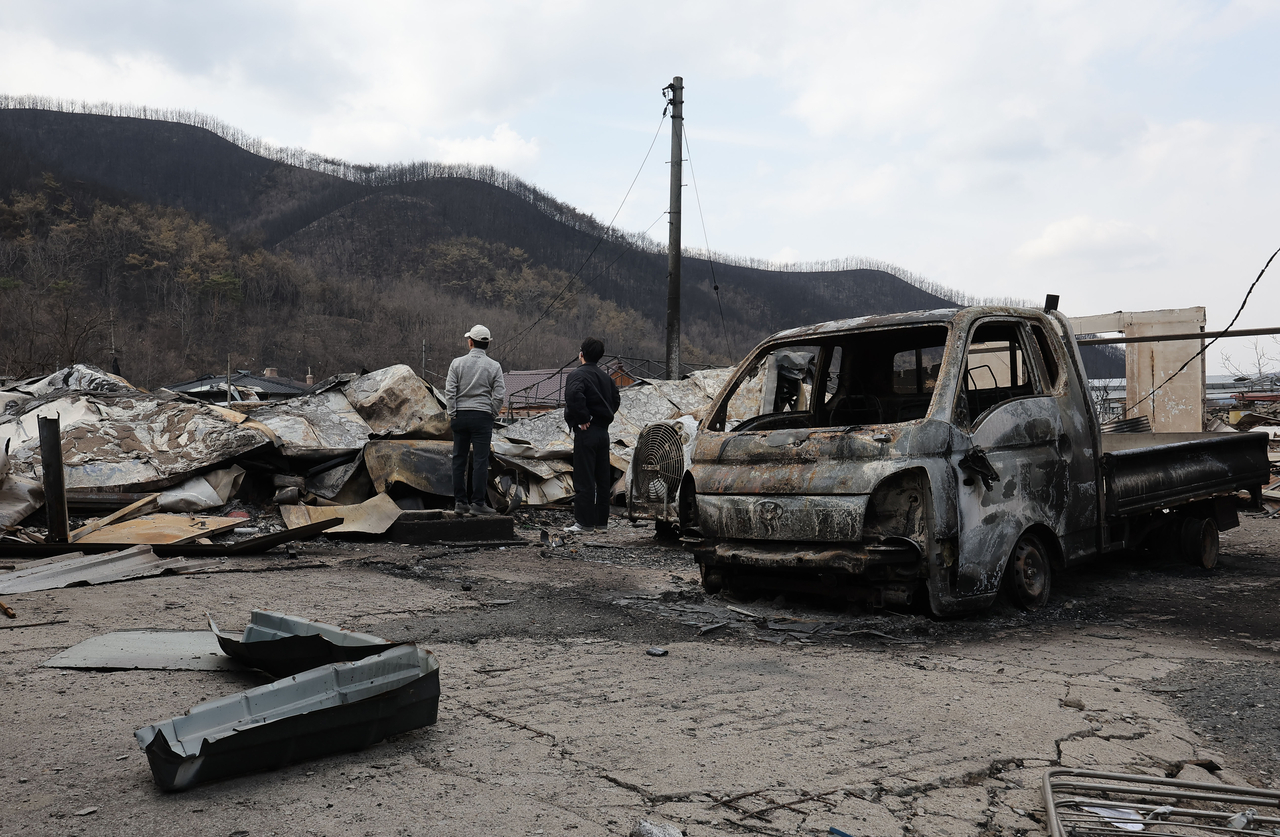 Residents affected by the wildfires assess damage at Andong, North Gyeongsang Province, Sunday. (Yonhap)