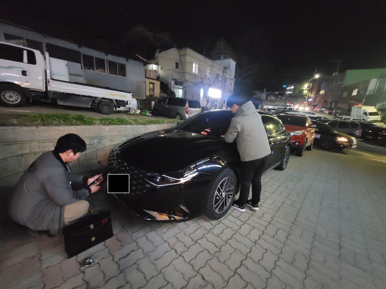 야간을 이용해 자동차 번호판을 영치하고 있다(울릉군 제공)