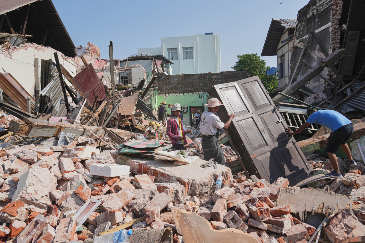 People carry their belongings as they leave their homes, damaged by Friday's earthquake in Naypyitaw, Myanmar, Tuesday. (AP-Yonhap)