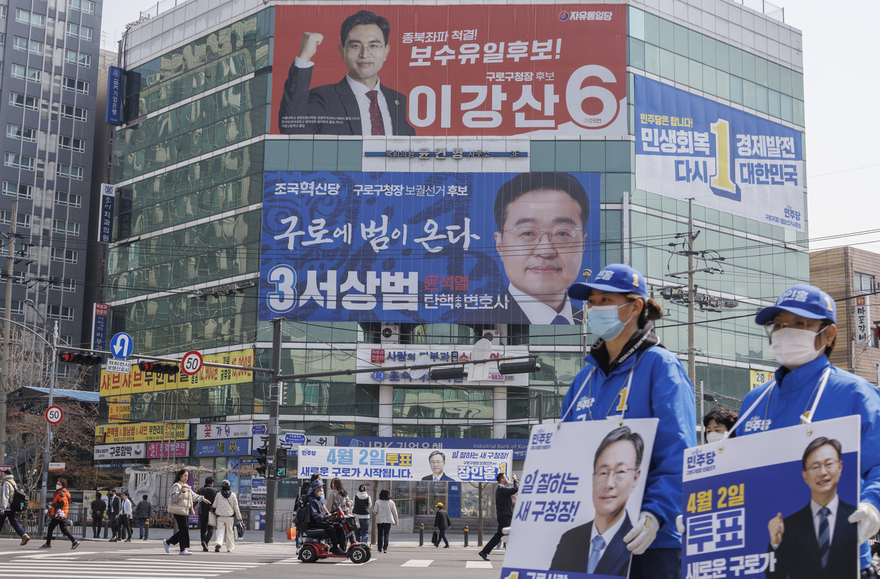 Banners for Guro-gu mayoral candidates adorn a building facade in Guro-gu, Seoul, on Tuesday, a day before a by-election. (Yonhap)