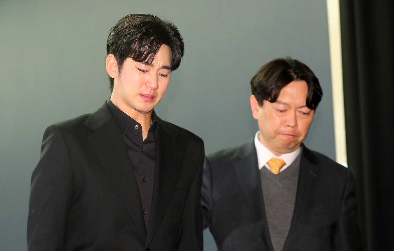 Kim Soo-hyun (left), leaves the press conference held in Sangam-dong, Seoul, Monday. (Newsis)