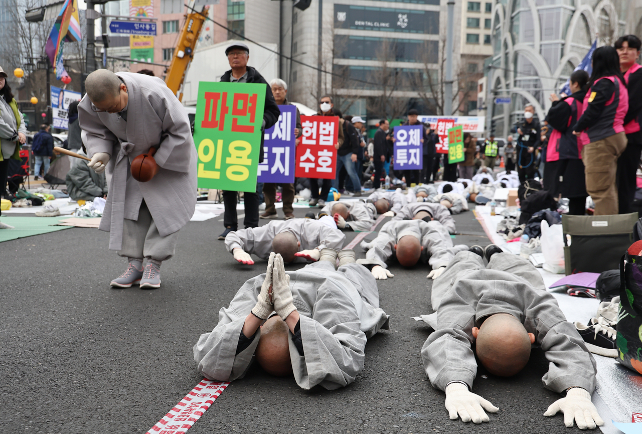 Monks from the Social Labor Committee of the Jogye Order of Korean Buddhism are performing a 'full-bowing' prostration march near Anguk Station in Jongno-gu, Seoul, on Wednesday. (Yonhap)