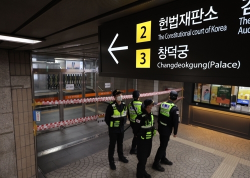 헌법재판소가 윤석열 대통령 탄핵심판 선고일을 발표한 1일 헌재 인근 서울 지하철 3호선 안국역 한 출입구를 기동복을 입은 경찰들이 통제하고 있다. 안국역은 선고 당일인 4일 첫 차부터 역을 폐쇄한 뒤 무정차 운행할 예정이다. 연합뉴스
