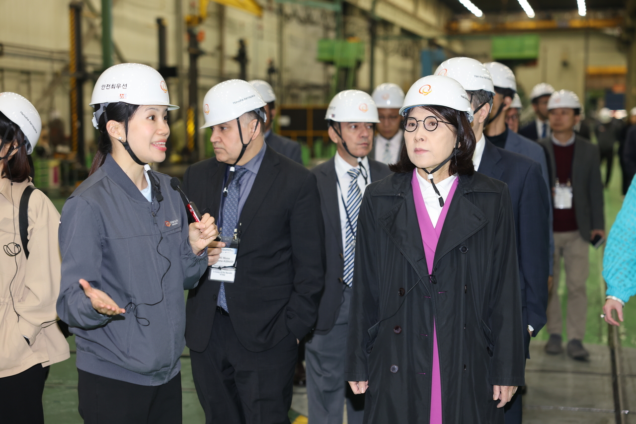 Second Vice Foreign Minister Kang In-sun (front right) and the diplomatic corps tour the assembly line of the K9 “Thunder” self-propelled howitzer at Hanwha Aerospace’s facility in Changwon, South Gyeongsang Province, Wednesday. (Republic of Korea Ministry of Foreign Affairs via Hanwha Aerospace)