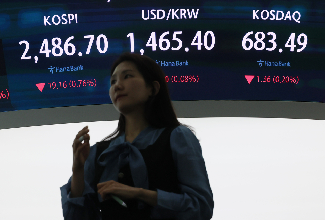 An electronic board shows movement on the Kospi and Kosdaq bourses, with the won-dollar exchange rate between them, at a dealing room of the Hana Bank headquarters in Seoul on Thursday. (Yonhap)