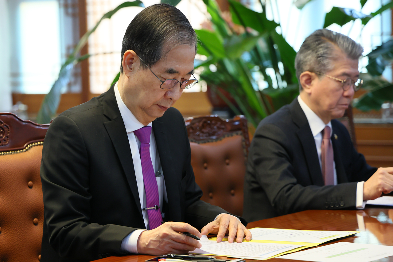 Acting President Han Duck-soo (left) presides over an emergency meeting of the economic and security strategy task force at his office in Seoul on Thursday. (Yonhap)