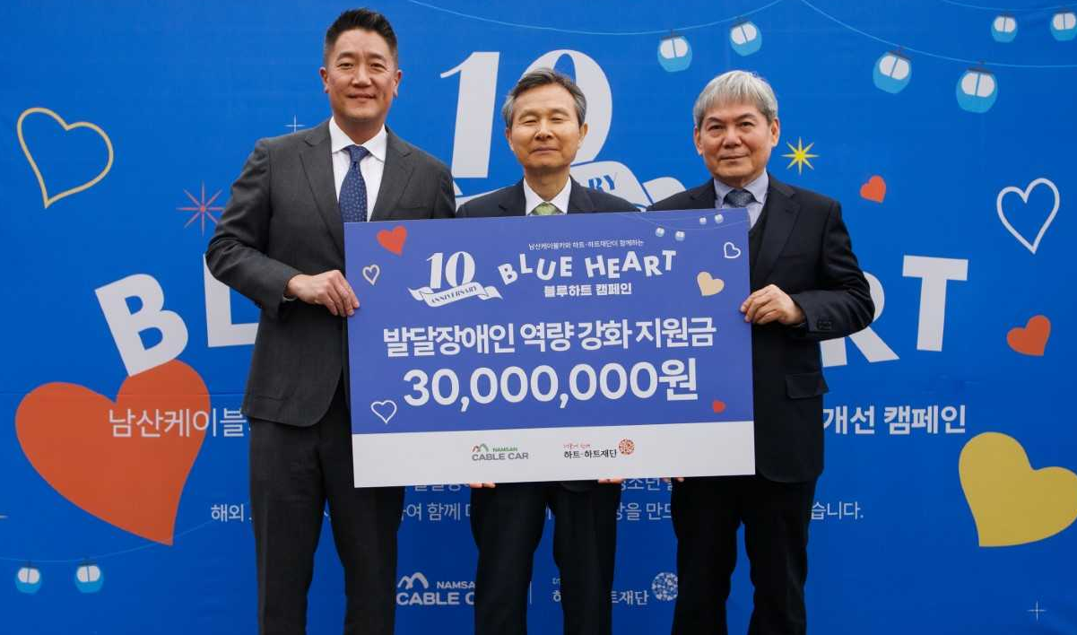 2일 남산케이블카 광장에서 열린 ‘블루하트 캠페인’ 10주년 전달식에 참석한 한국삭도공업 및 하트-하트재단 관계자들이 기념 촬영을 하고 있다.(사진 출처: 하트-하트재단)