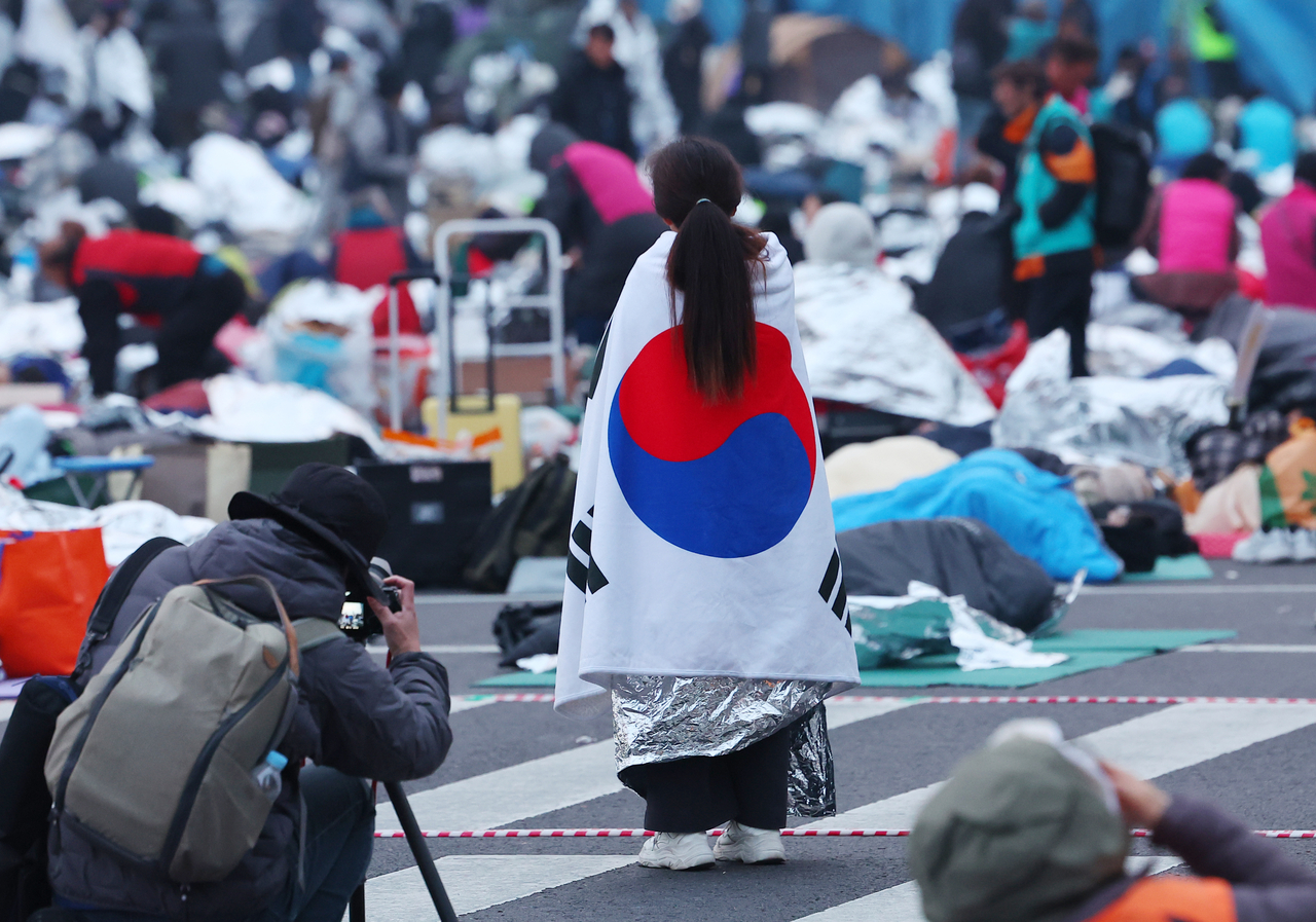 Protestors gather to call for the confirmation of Yoon Suk Yeol's impeachment at Anguk Station near the Constitutional Court in central Seoul on Friday morning, following an all-night protest. (Yonhap)