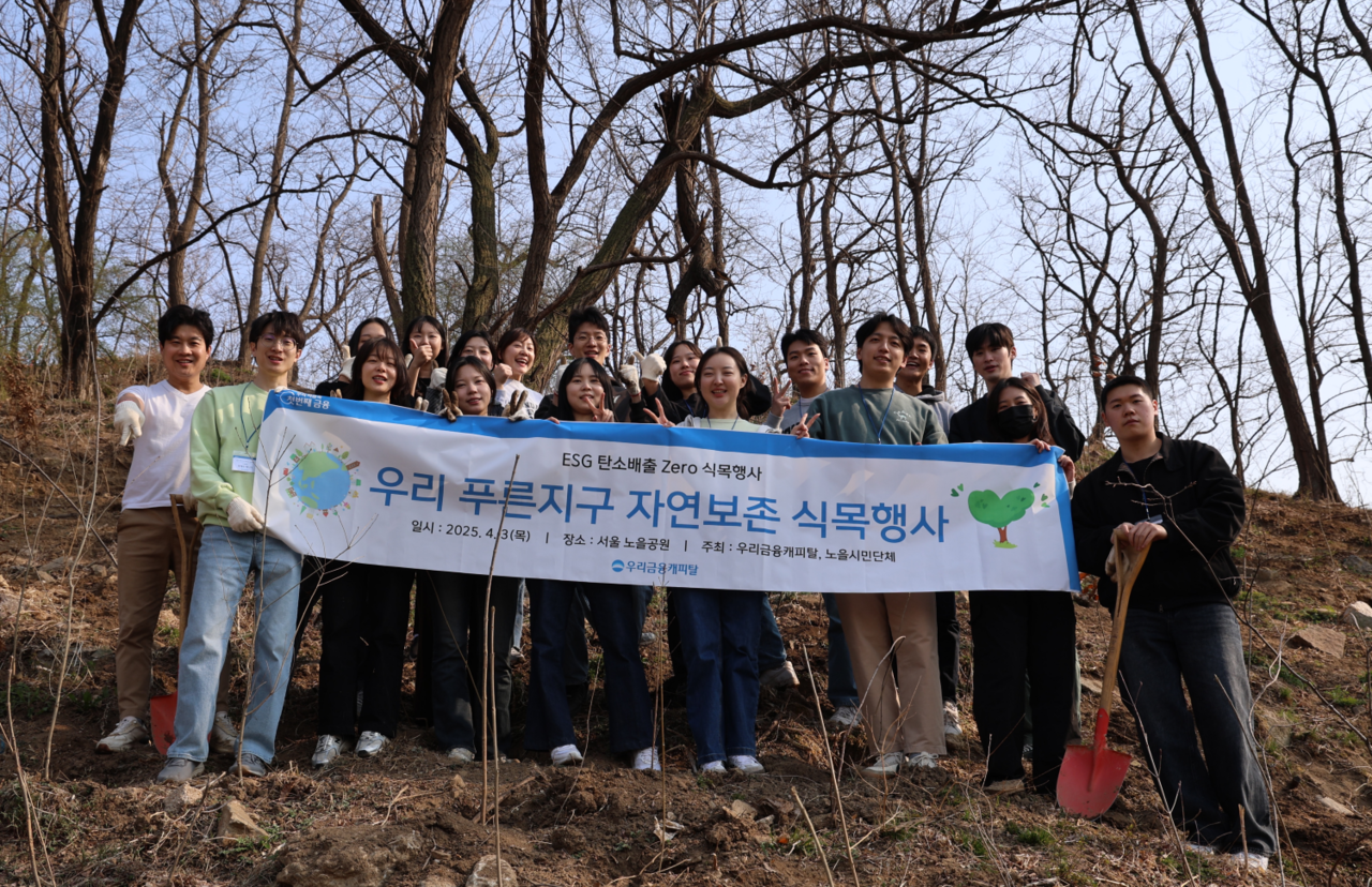 우리금융캐피탈 신입사원 등 임직원이 지난 3일 서울 상암동 노을공원에서 ‘탄소배출 제로(Zero)’를 실천하는 나무심기 봉사활동을 한 후 기념촬영을 하고 있다. [우리금융 제공]