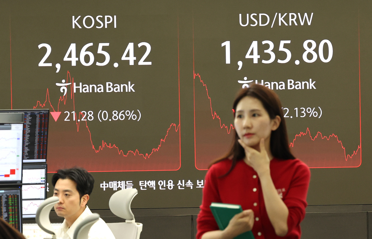 4일 서울 중구 하나은행 딜링룸에서 한 딜러가 자료를 살피고 있다. 이날 코스피는 전장보다 21.28포인트(0.86%) 내린 2,465.42에 장을 마감했다. 원/달러 환율은 32.9원 내린 1,434.1원. [연합]