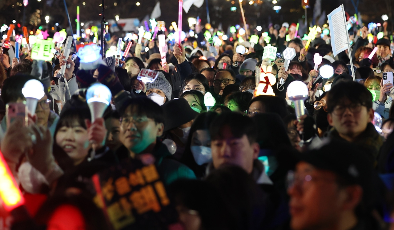 After the vote to impeach President Yoon Suk Yeol was passed on Dec. 14, 2024, massive crowds outside the National Assembly celebrate, waving light sticks and singing protest anthems. (Yonhap)