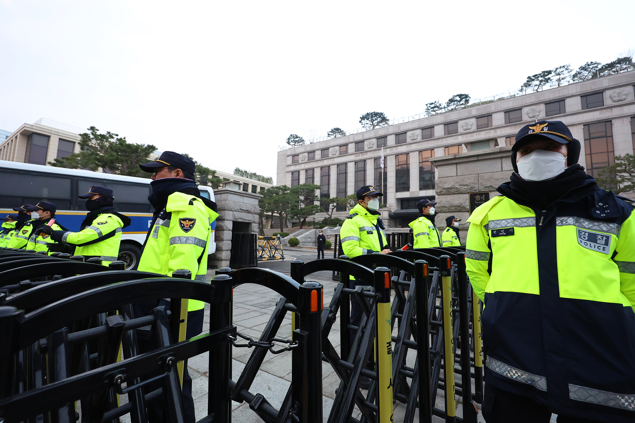 Police officials guard the entrance to the Constitutional Court on the day of its ruling on President Yoon Suk Yeol's impeachment on Friday. (Yonhap)