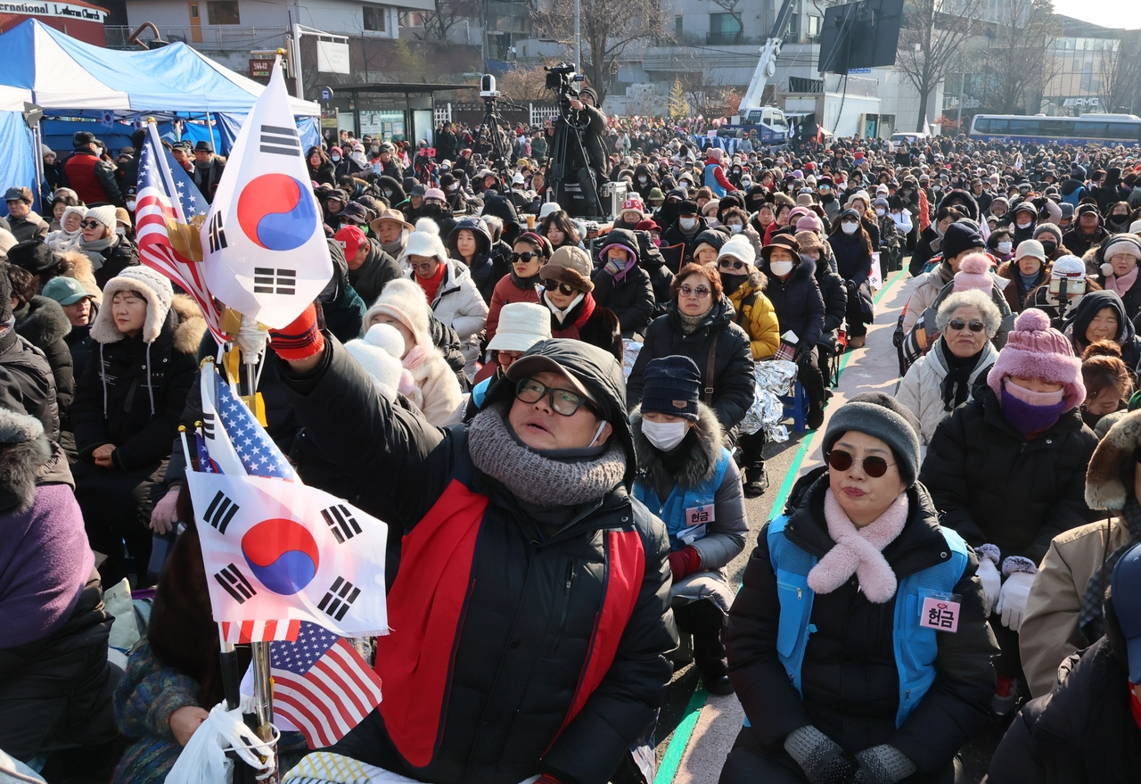 On Jan. 12, thousands of pro-Yoon demonstrators fill the streets near his residence, waving flags and chanting against impeachment. Many echo slogans from US right-wing rallies, accusing the opposition of staging a political coup. (Yonhap)