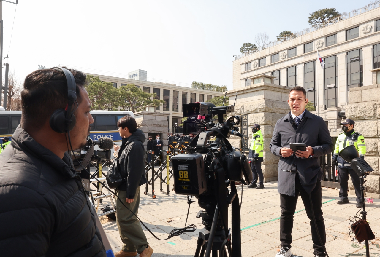 International correspondents prepare for live coverage outside the Constitutional Court in Seoul on April 4, ahead of the final ruling on President Yoon Suk Yeol’s impeachment. (Yonhap)