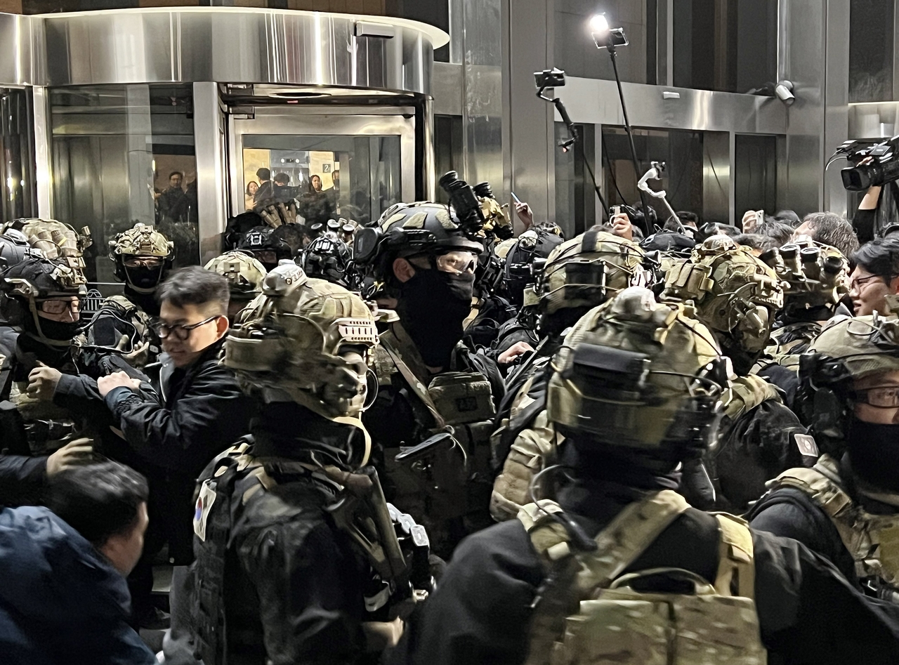 In the wee hours of Dec. 4, 2024, soldiers in full combat gear attempt to block access to the National Assembly, as lawmakers rush to nullify the president’s martial law decree in an emergency vote. (Yonhap)