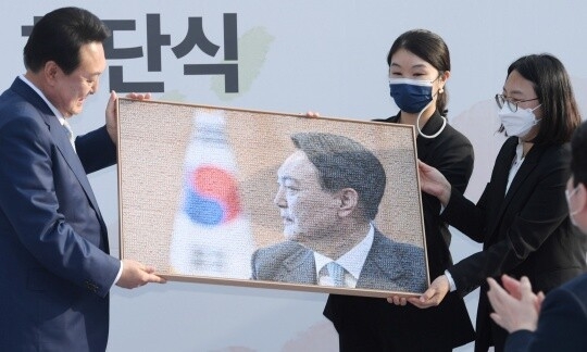 국방부와 합동참모본부, 육·해·공군·해병대 등 각급 군부대에 걸려 있던 윤석열 전 대통령의 사진이 4일 파면과 함께 전부 세절·소각된다. 윤 전 대통령이 당선인 시절 대통령직인수위원회 해단식에서 사진을 전달받는 모습. [인수위사진기자단]