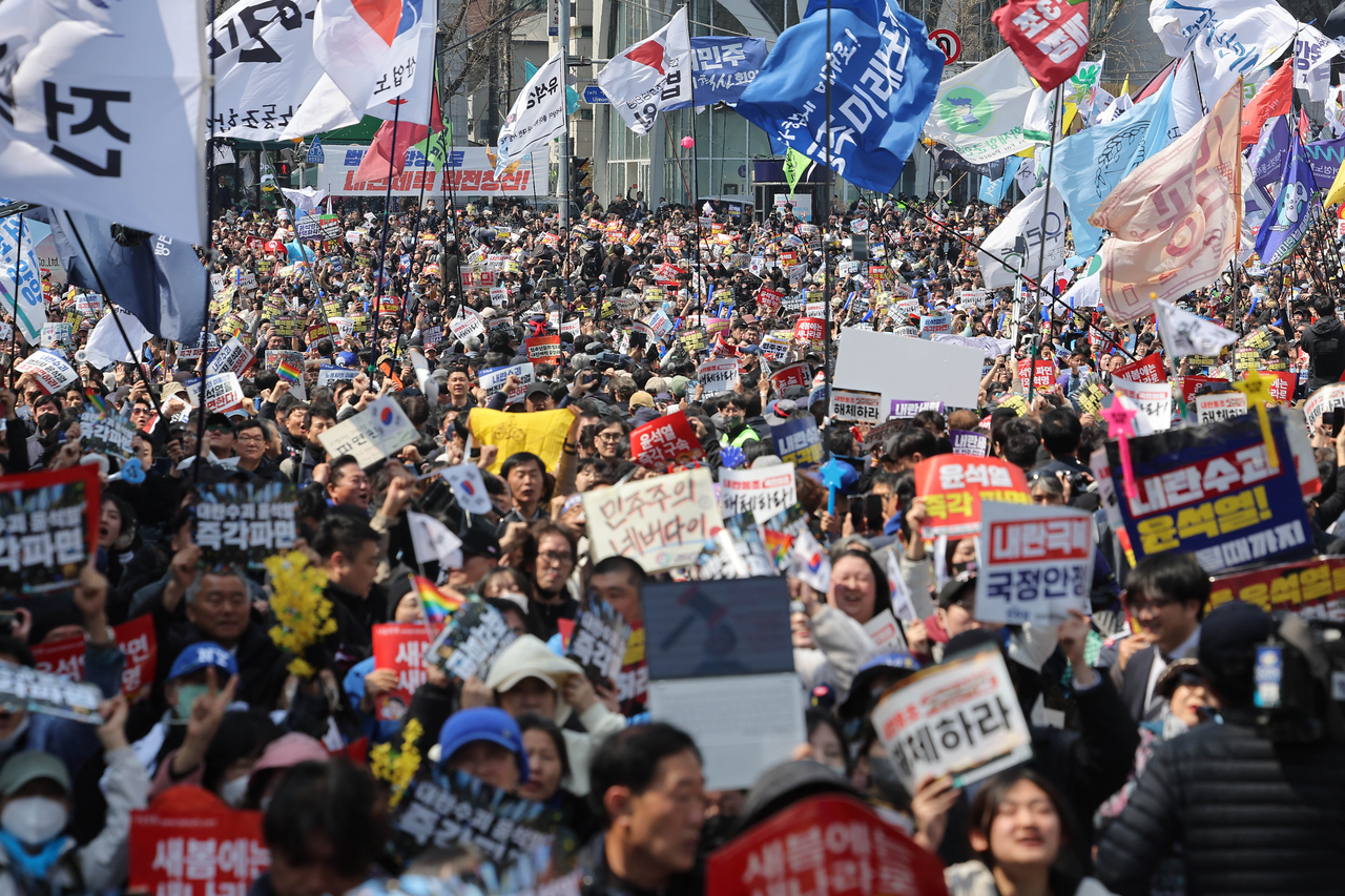 Citizens who supported the impeachment of President Yoon Suk Yeol celebrate in Anguk-dong, Jongno-gu, Seoul, on Friday, after the Constitutional Court ruled in favor of the impeachment. (Yonhap)