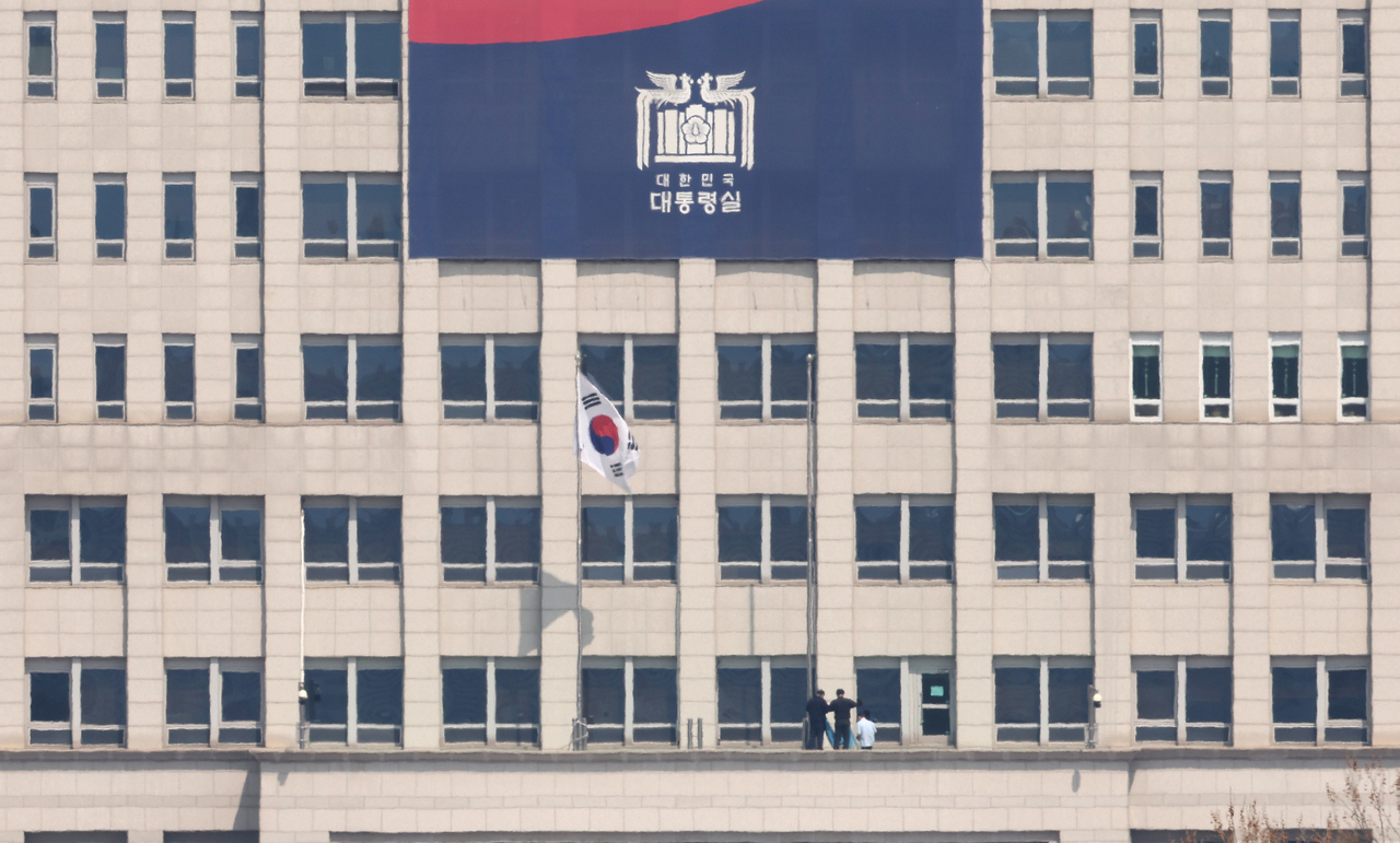 헌법재판소가 윤석열 대통령 파면을 선고한 4일 서울 용산구 대통령실에서 관계자들이 봉황기를 내리고 있다. <연합>