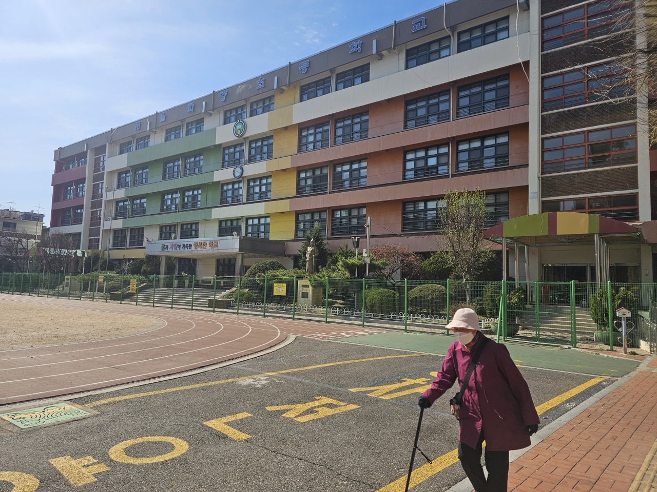 Ryu Myung-jin, 73, walks with a cane at the now-closed Hwayang Elementary School on March 28. She exercises here every day since the school was closed in February last year due to a shortage of students.(Choi Jae-hee / The Korea Herald)