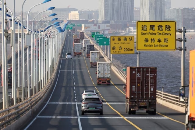 Trucks loaded with shipping containers pass over Donghai Bridge to exit Yangshan Port outside of Shanghai, China, Feb. 7. (Reuters)