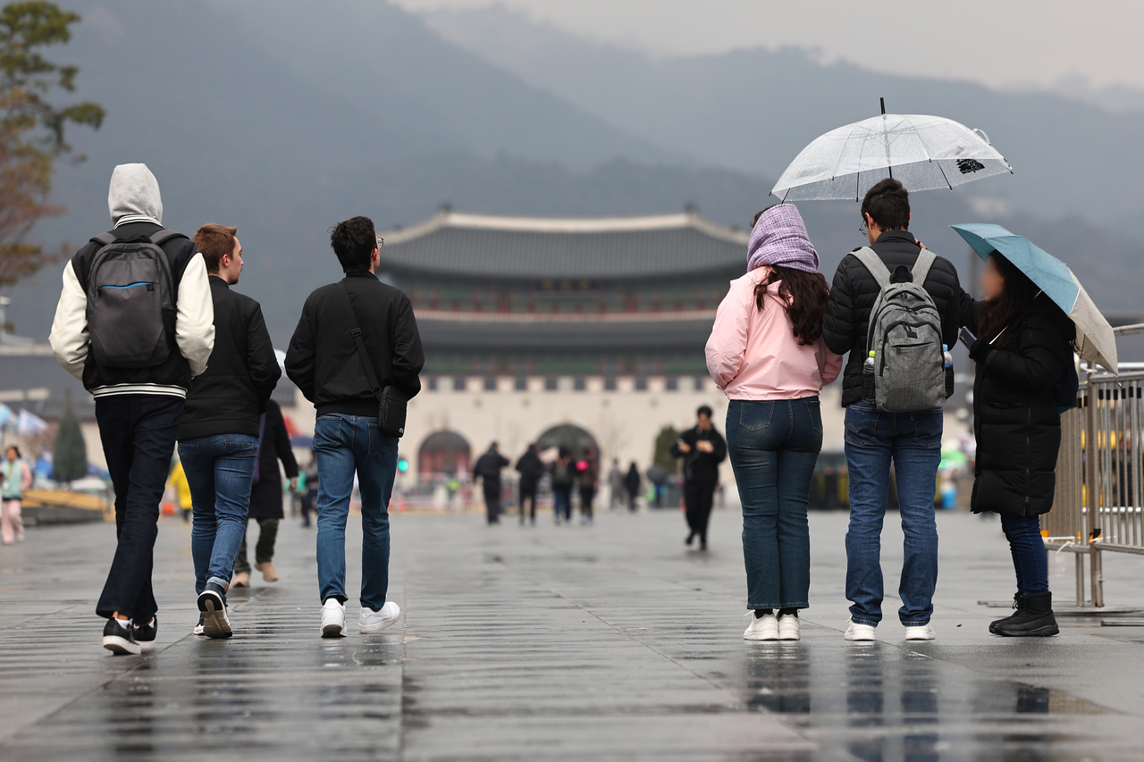 지난 16일 서울 종로구 광화문 광장에서 우산을 쓰거나 쓰지 않은 관광객들이 이동하고 있다. [연합]