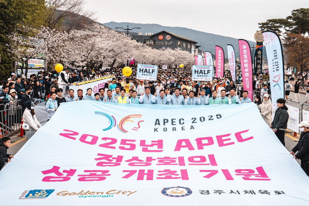 지난 5일 경주 보문관광단지에서 열린 제32회 경주벚꽃마라톤대회에서 주낙영 경주시장을 비롯한 내빈과 참가자들이 ‘2025년 APEC 정상회의 성공개최 기원’ 문구가 적힌 대형 현수막을 펼치고 있다.[경주시 제공]
