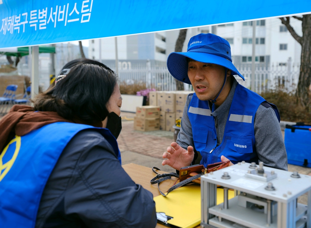 삼성전자서비스 재난복구특별서비스팀 직원이 지난 3월 28일 경북 의성 실내체육관에 마련된 이재민 대피소에서 가전제품의 무상 점검·수리를 위해 산불 피해 주민과 상담하고 있다. [삼성전자서비스 제공]