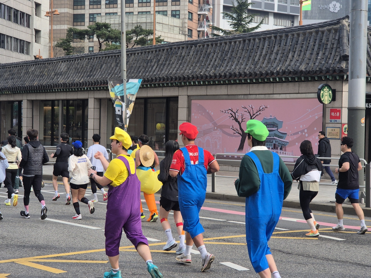 6일 오전 서울 종로구 광화문광장에서 열린 ‘2025 더 레이스 서울 21K’ 마라톤 대회에서 참가자들이 광장을 출발해 도심을 달리고 있다.  게임 캐릭터 ‘마리오, 루이지, 와리오’오‘복자을 한 참가자가 달리고 있다. 김도윤 기자.