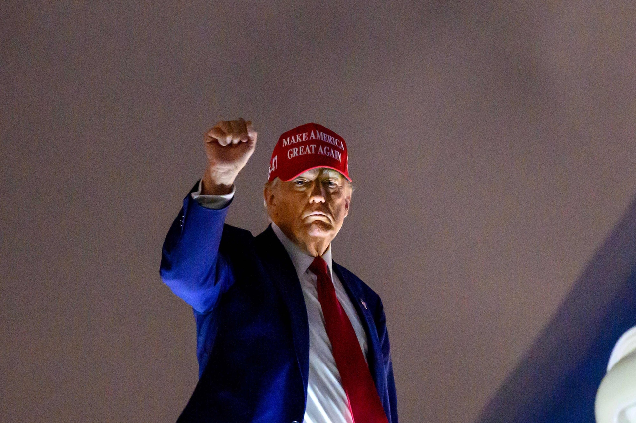 US President Donald Trump pumps his fist as he boards Air Force One before departing Miami International Airport, in Miami, Florida on Thursday. Trump is travelling to his Mar-a-Lago Resort. (AFP)