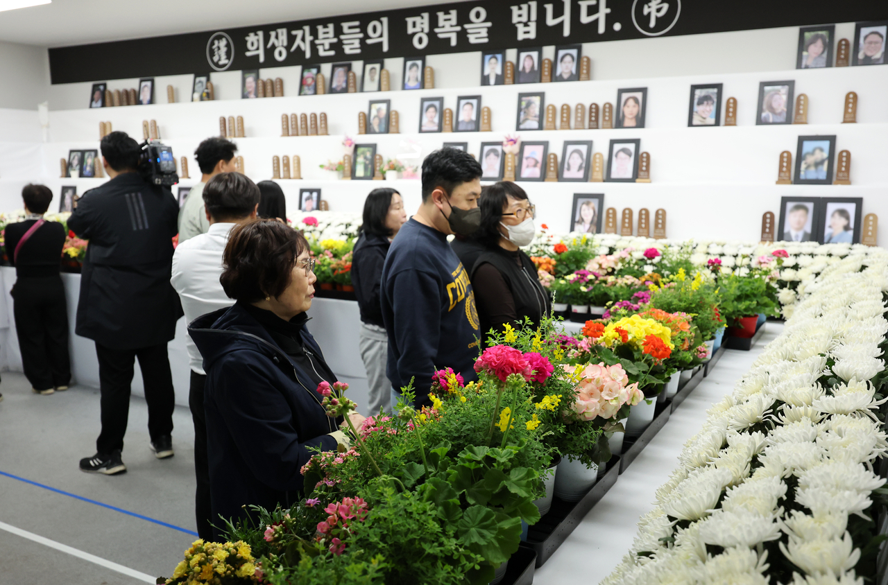 People pay tribute at a memorial altar set up at Muan International Airport in South Jeolla Province on Monday, marking the 100th day since the Dec. 29 Jeju Air crash that claimed 179 lives. (Yonhap)