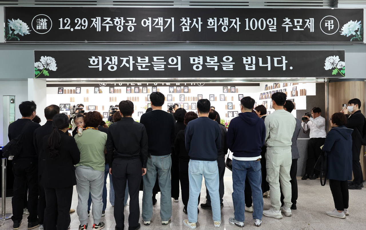 Bereaved families pay tribute at a memorial altar set up at Muan International Airport in South Jeolla Province on Monday, marking the 100th day since the Dec. 29 Jeju Air crash that claimed 179 lives. (Yonhap)