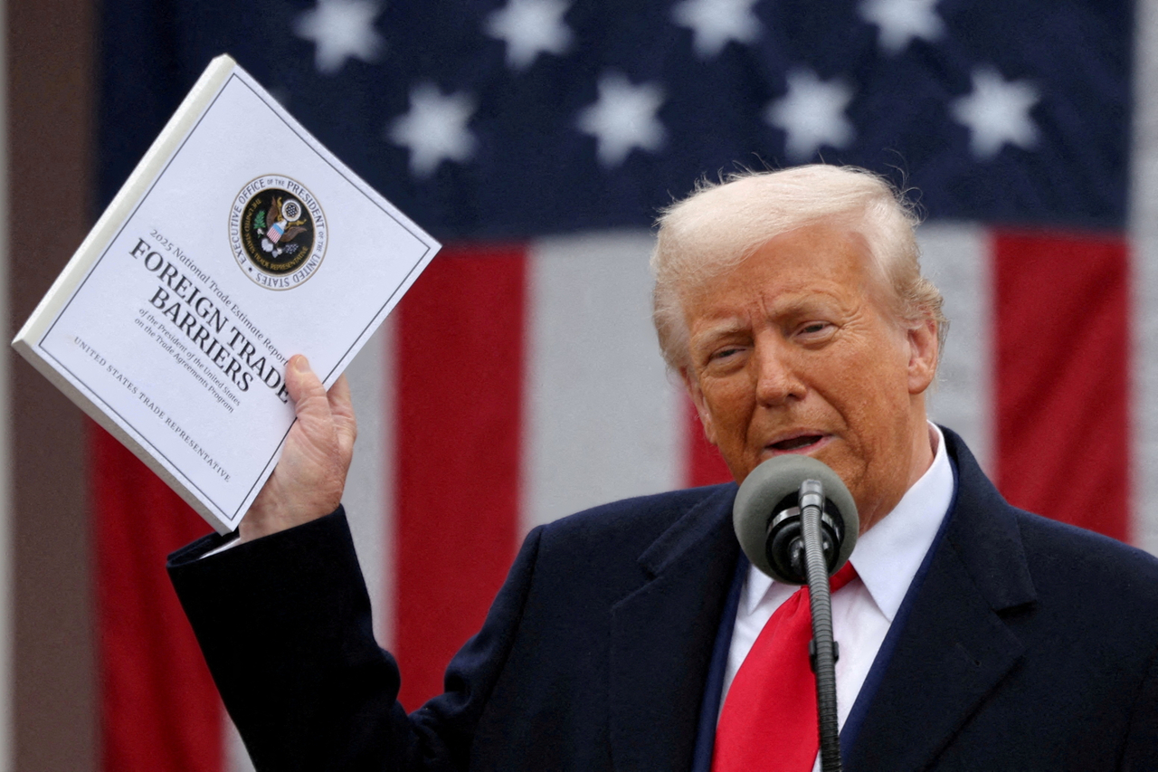 US President Donald Trump holds a "Foreign Trade Barriers" document as he delivers remarks on tariffs in the Rose Garden at the White House on Wednesday. (Reuters-Yonhap)