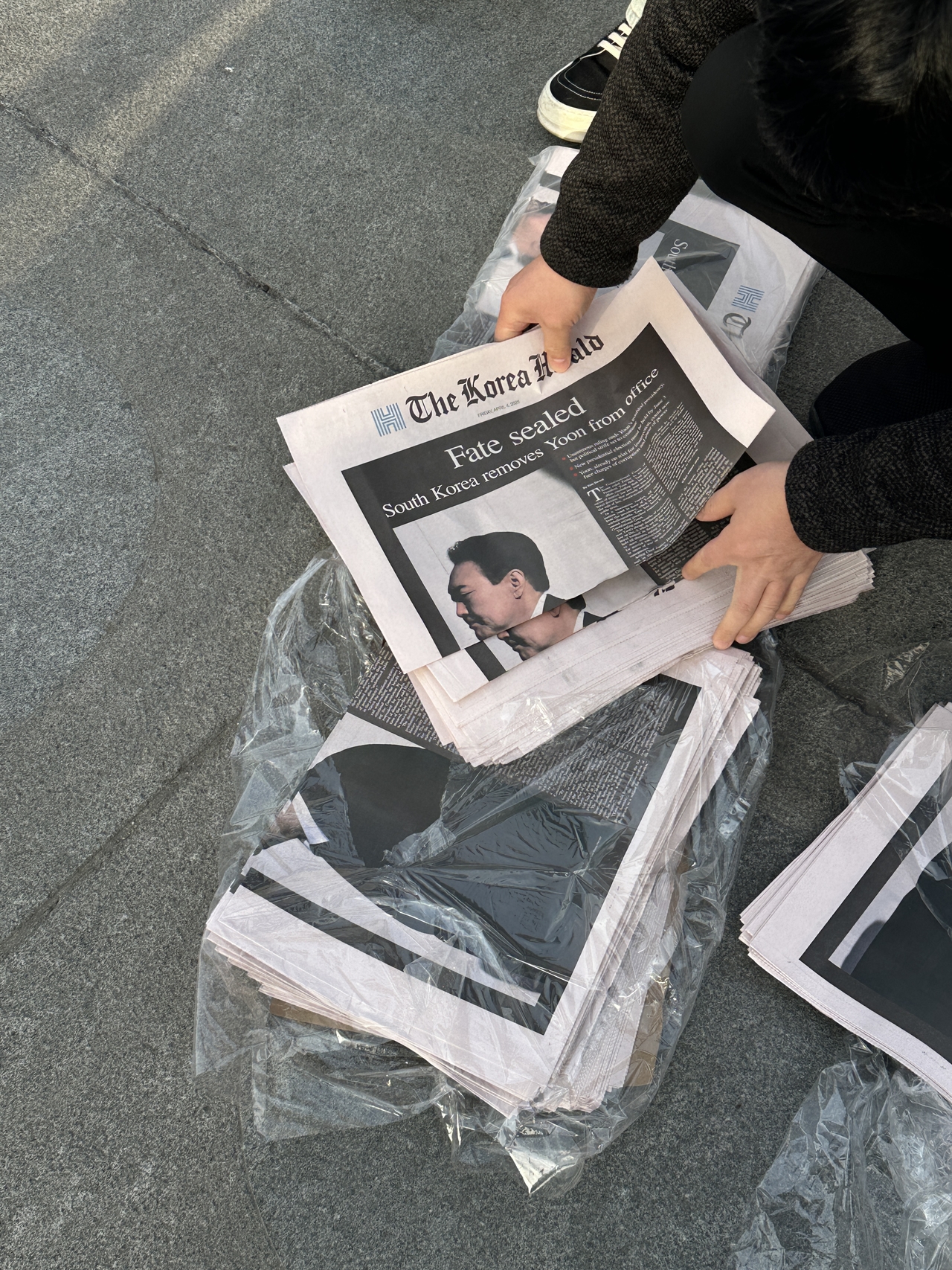 A citizen picks up an extra edition of The Korea Herald on April 4 in Gwanghwamun Square. (The Korea Herald)