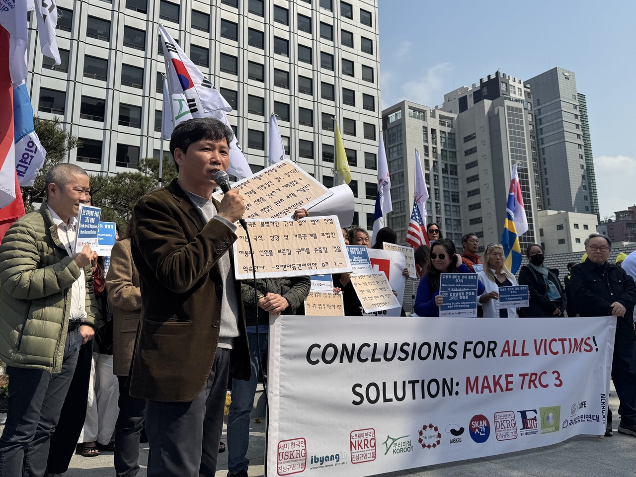 Cho Min-ho, director of Children’s Rights Solidarity, holds printed excerpts from the UN Convention on the Rights of the Child as he speaks during a rally outside the Truth and Reconciliation Commission in Seoul on April 10, where adoptees and 11 advocacy groups called for a new investigation into adoption abuses. (Moon Joon Hyun/The Korea Herald)