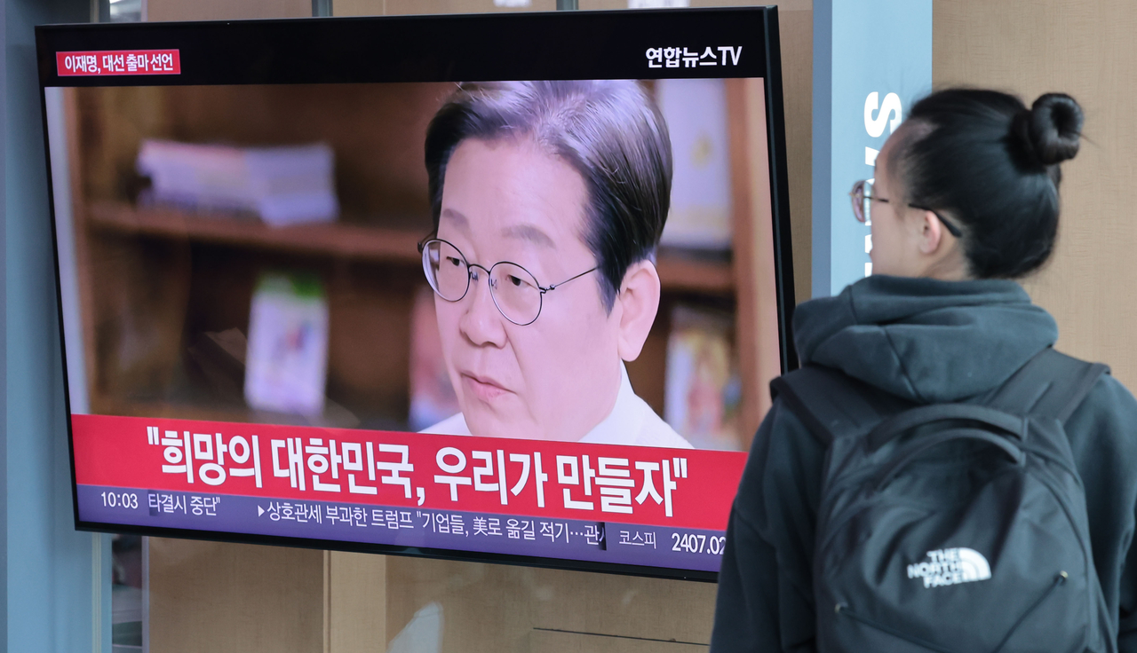 10일 서울역 대합실에서 한 시민이 이재명 전 더불어민주당 대표의 대통령 선거 출마 선언 영상을 지켜보고 있다.  [연합]