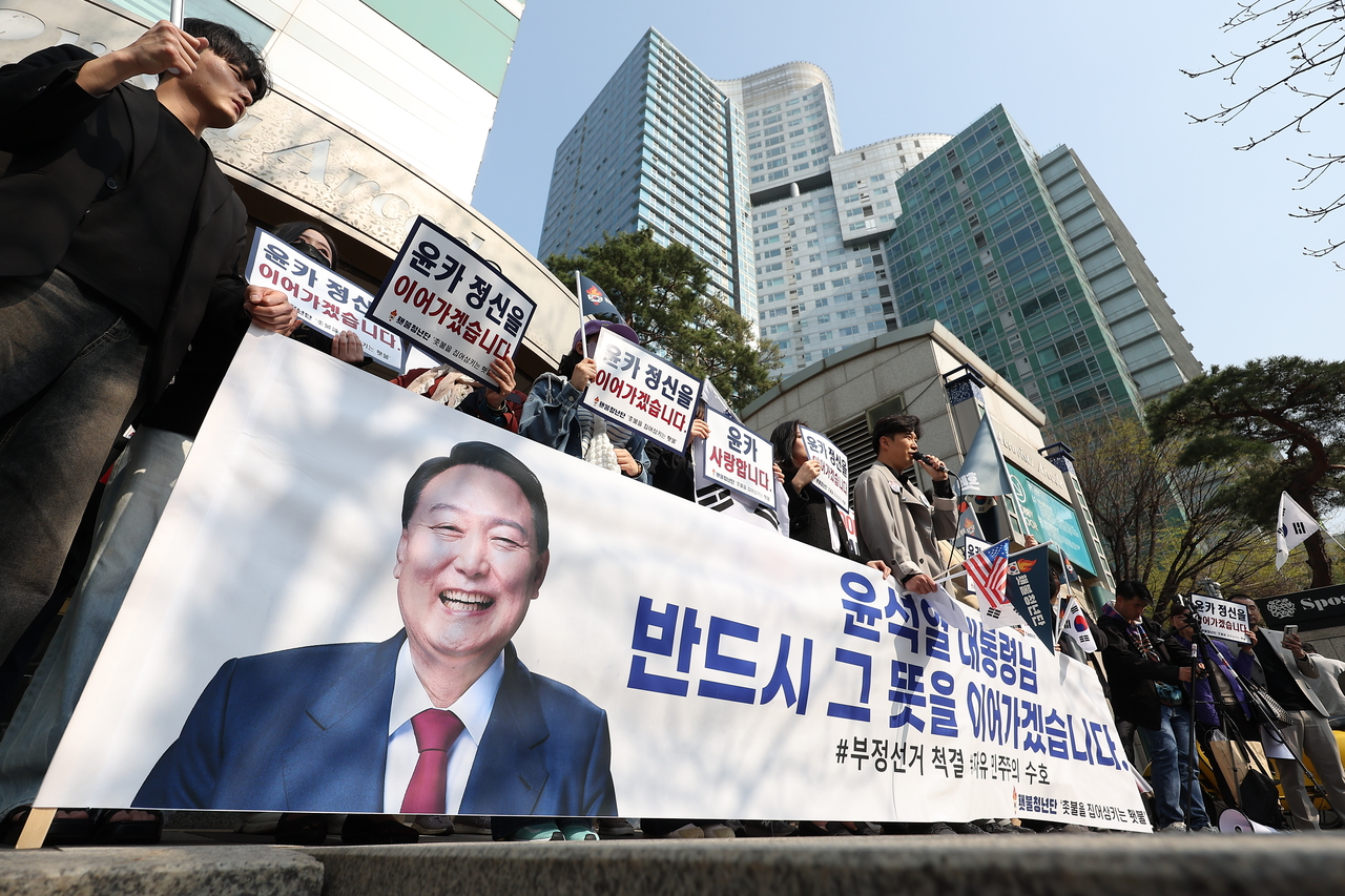 Supporters of ex-President Yoon Suk Yeol hold banners in support of Yoon outside his personal residence in Seocho-gu, southern Seoul, Friday. (Yonhap)