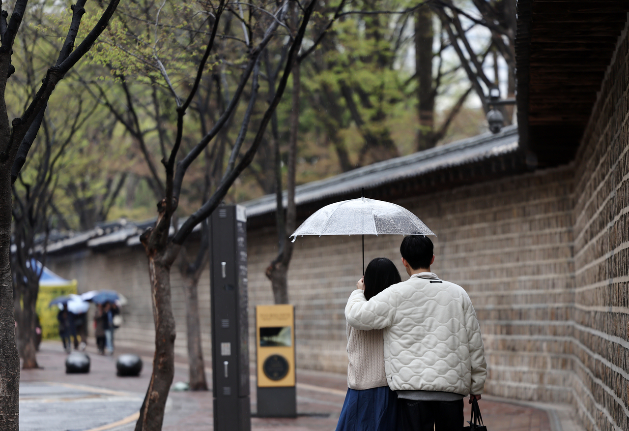 비 내리는 12일 시민들이 우산을 쓴 채 서울 정동길을 걷고 있다. [연합]