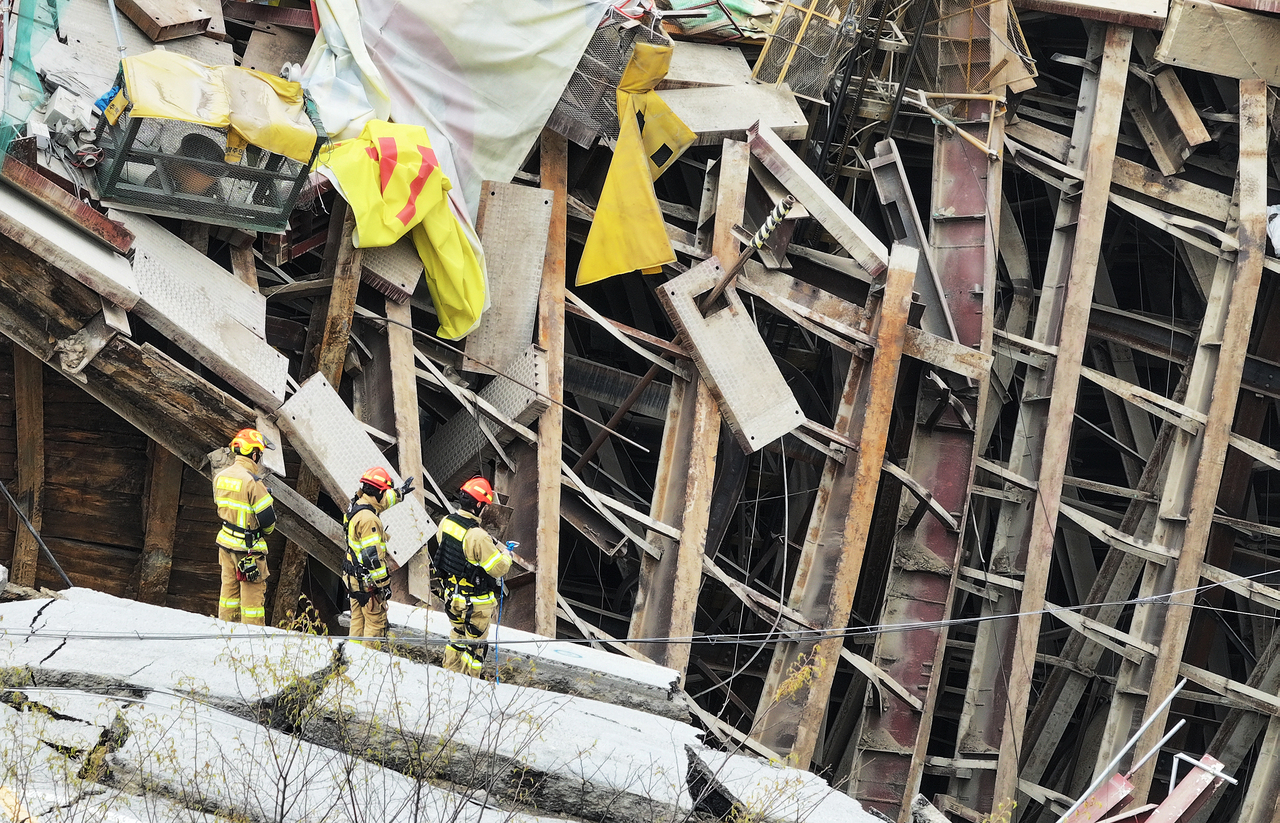 Rescue personnel conduct search operations for the missing construction worker at a collapsed subway construction site in Gwangmyeong, Gyeonggi Province, Saturday. (Yonhap)