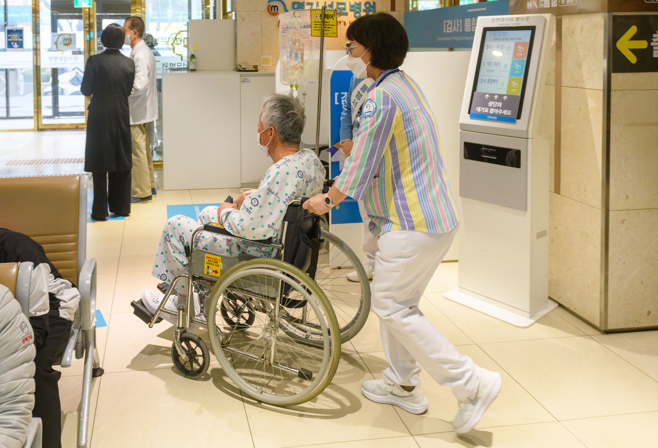 A medical worker transports a patient in a wheelchair at a hospital in Seoul. (Getty Images)
