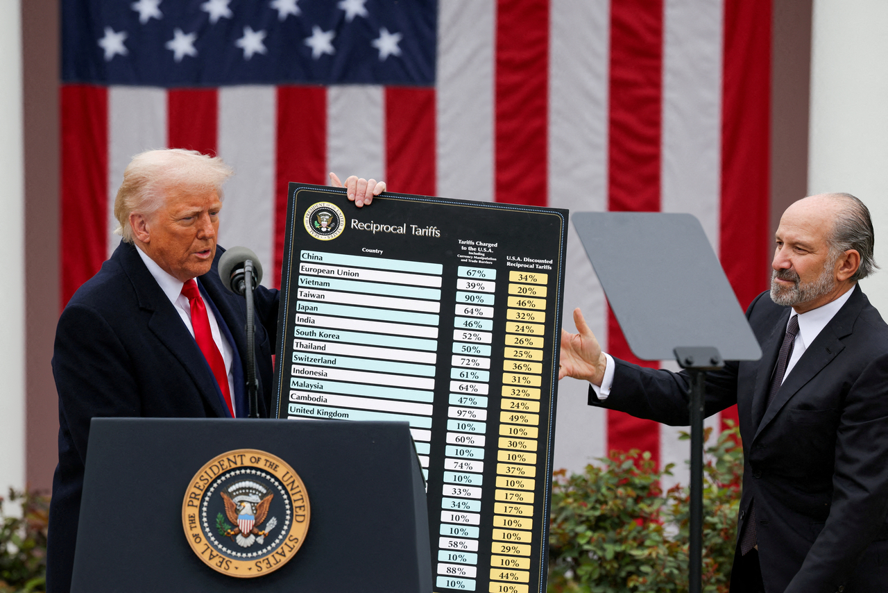 US President Donald Trump holds a chart next to US Secretary of Commerce Howard Lutnick as Trump delivers remarks on tariffs in the Rose Garden at the White House in Washington on April 2. Reuters-Yonhap