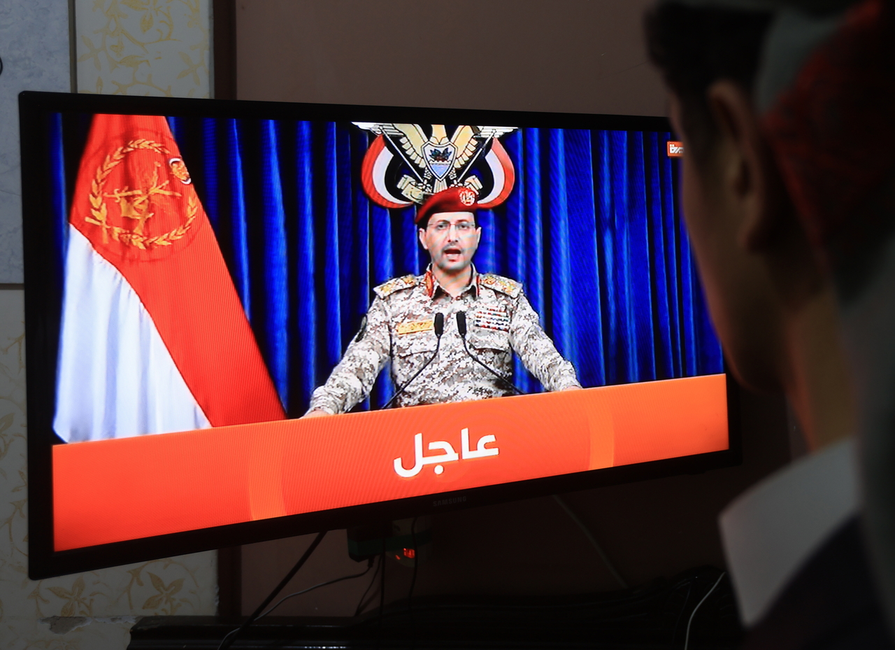 A person watches a Houthi military spokesperson speaking in Sanna, Yemen, Sunday. (EPA-Yonhap)
