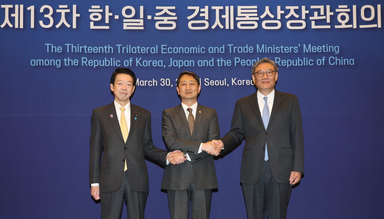 From left: Japanese Trade Minister Yoji Muto, South Korean Industry Minister Ahn Duk-geun and Chinese Commerce Minister Wang Wentao pose for a photo ahead of their trilateral trade ministers' meeting in Seoul on March 30. (Yonhap)