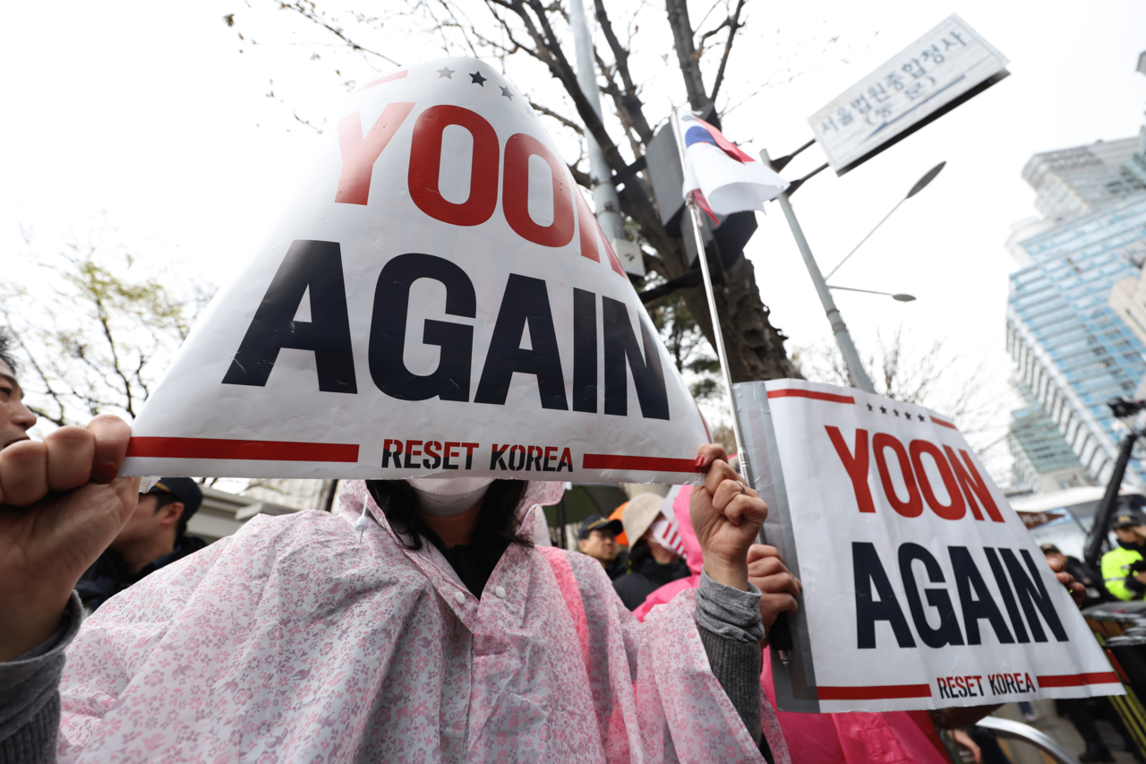 Protesters are seen holding “Yoon Again” signs in support of former President Yoon Suk Yeol in front of Seoul Central District Court on Monday, as Yoon’s criminal trial on charges of orchestrating an insurrection through declaring martial law Dec. 3 was taking place. (Yonhap)