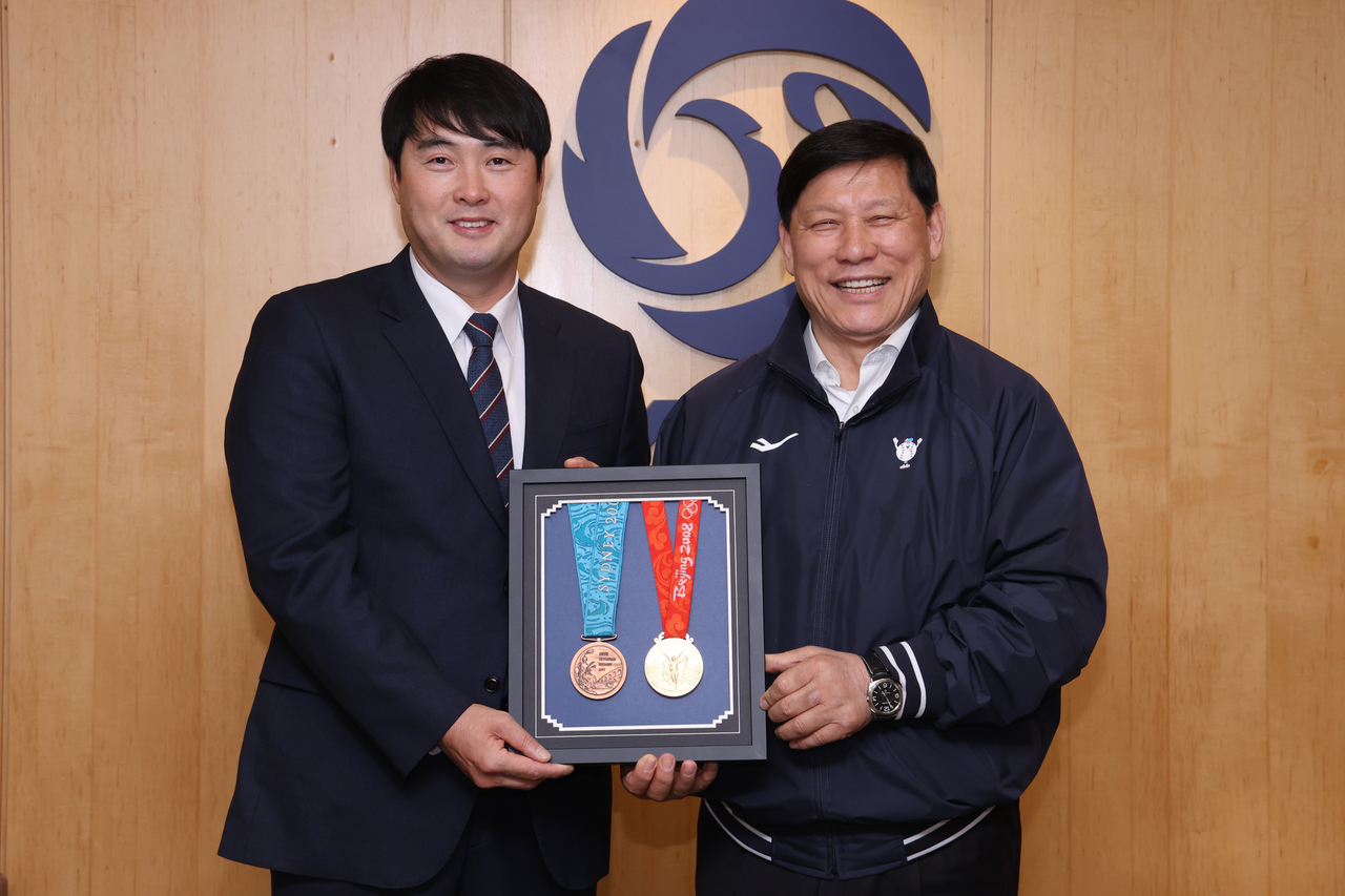 정대현(왼쪽) 삼성 라이온즈 수석코치가 야구박물관에 베이징올림픽 금메달과 시드니올림픽 동메달을 기증하며 허구연 KBO 총재와 기념촬영을 하고 있다.   [KBO 제공]